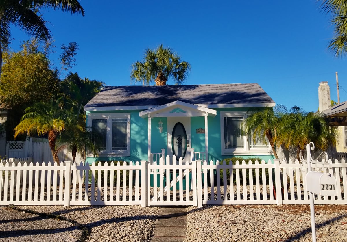 Turquoise cottage with white picket fence Gulfport Florida
