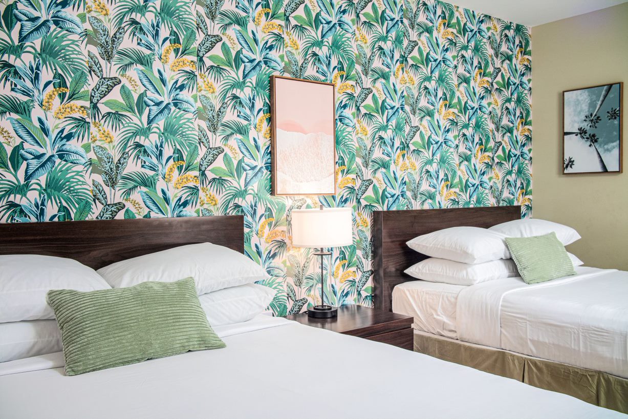 A bedroom with palm frond wallpaper at The Local - St. Augustine