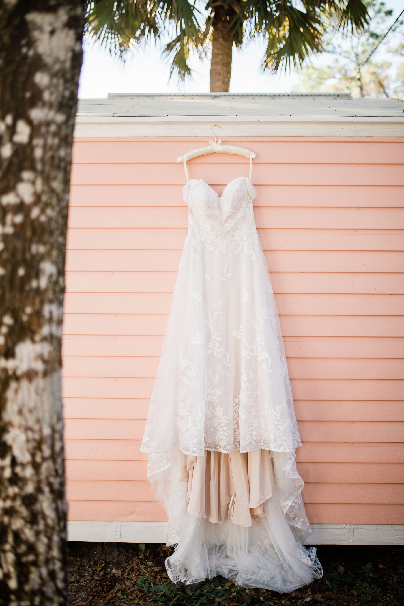Mae's wedding dress hanging on the side of the pink shed, so beautiful!