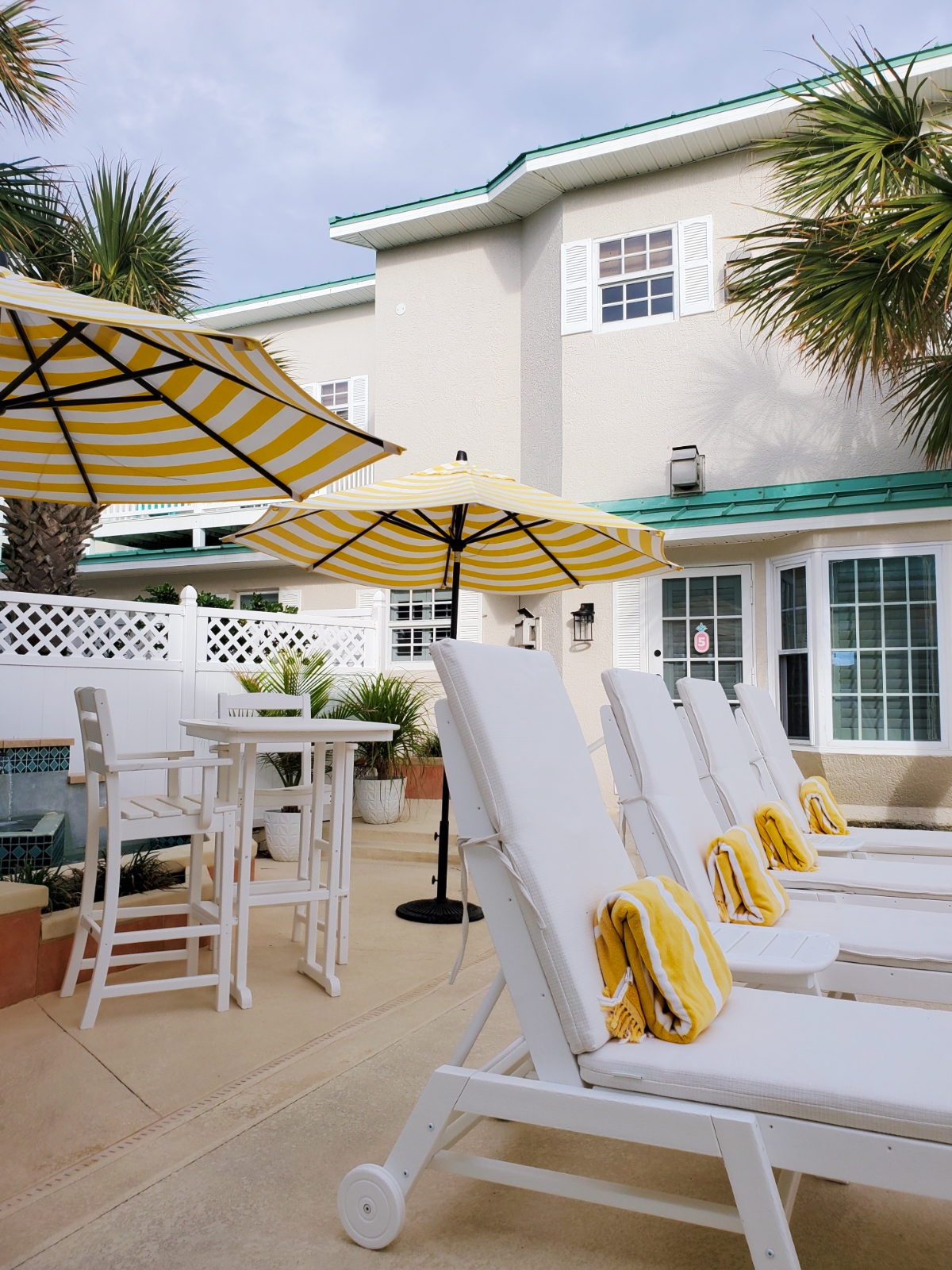 Island Cottage Inn pool lounges, umbrellas, cozy high top tables for coffee or wine
