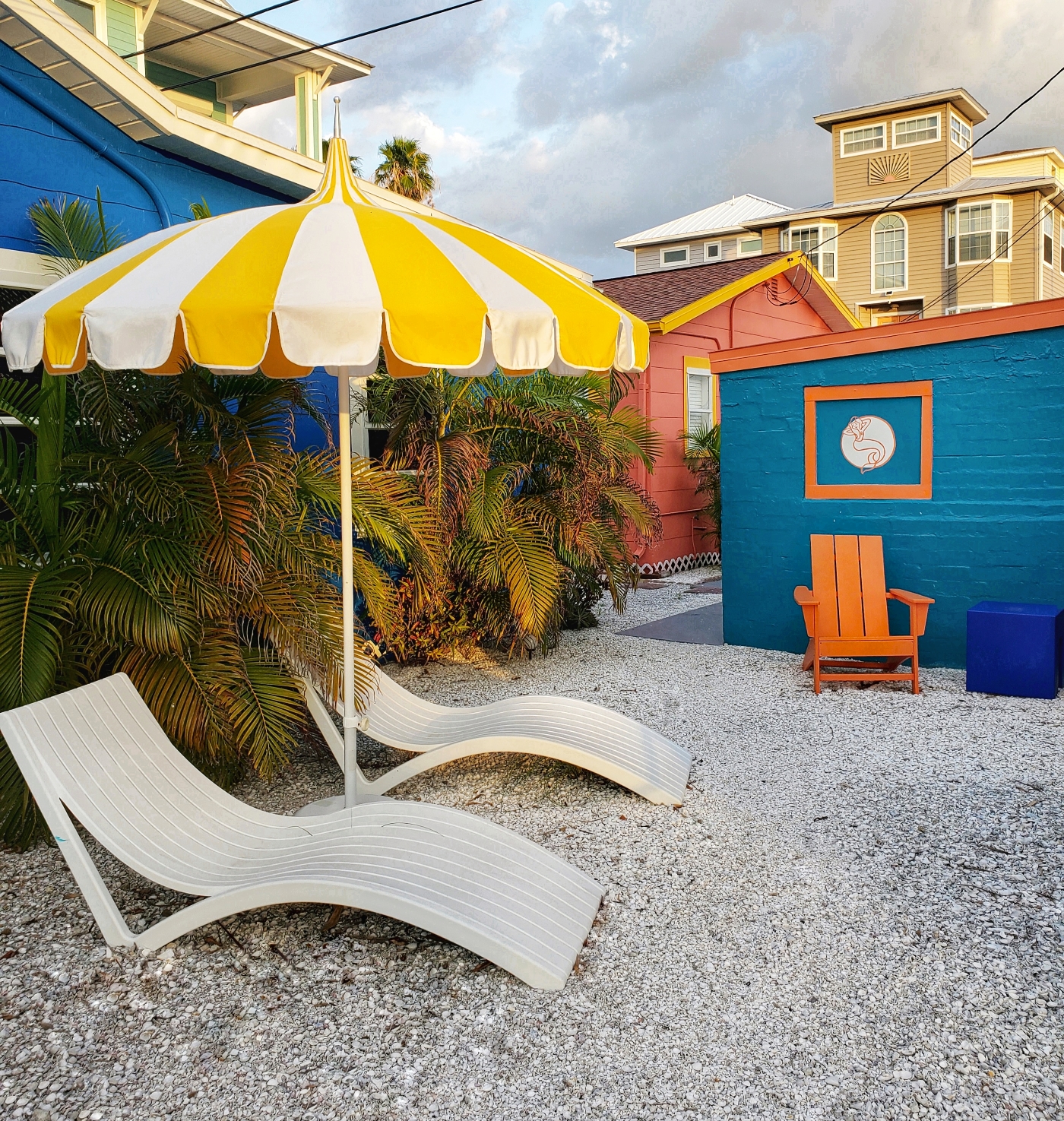 Sunset Inn Treasure Island, one of the intimate fun courtyards with striped umbrella, chairs, surrounded by colorful cottages